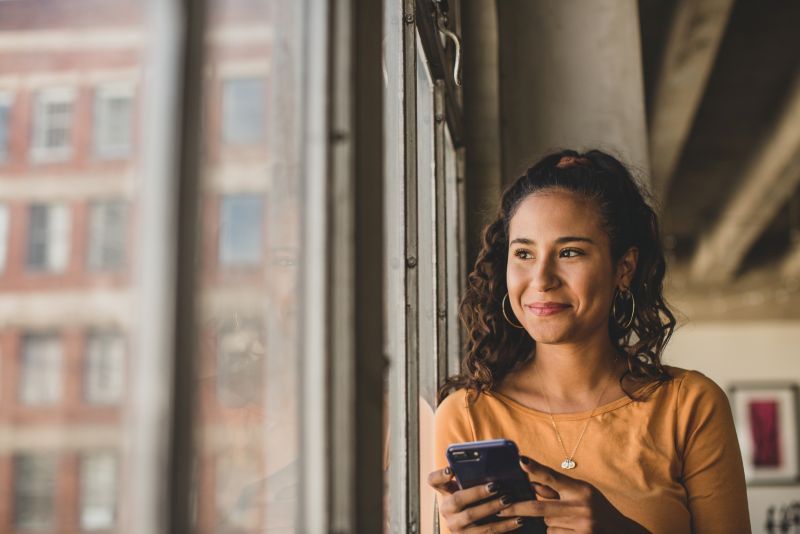 happy young woman looking out window 800